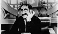 Groucho Marx med tykt overskæg og runde briller, som holde ren cigar
